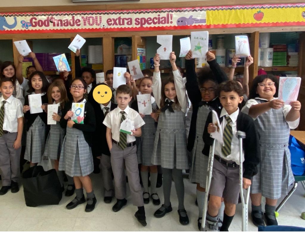 Third grade students at St. Peter School hold up handmade cards.