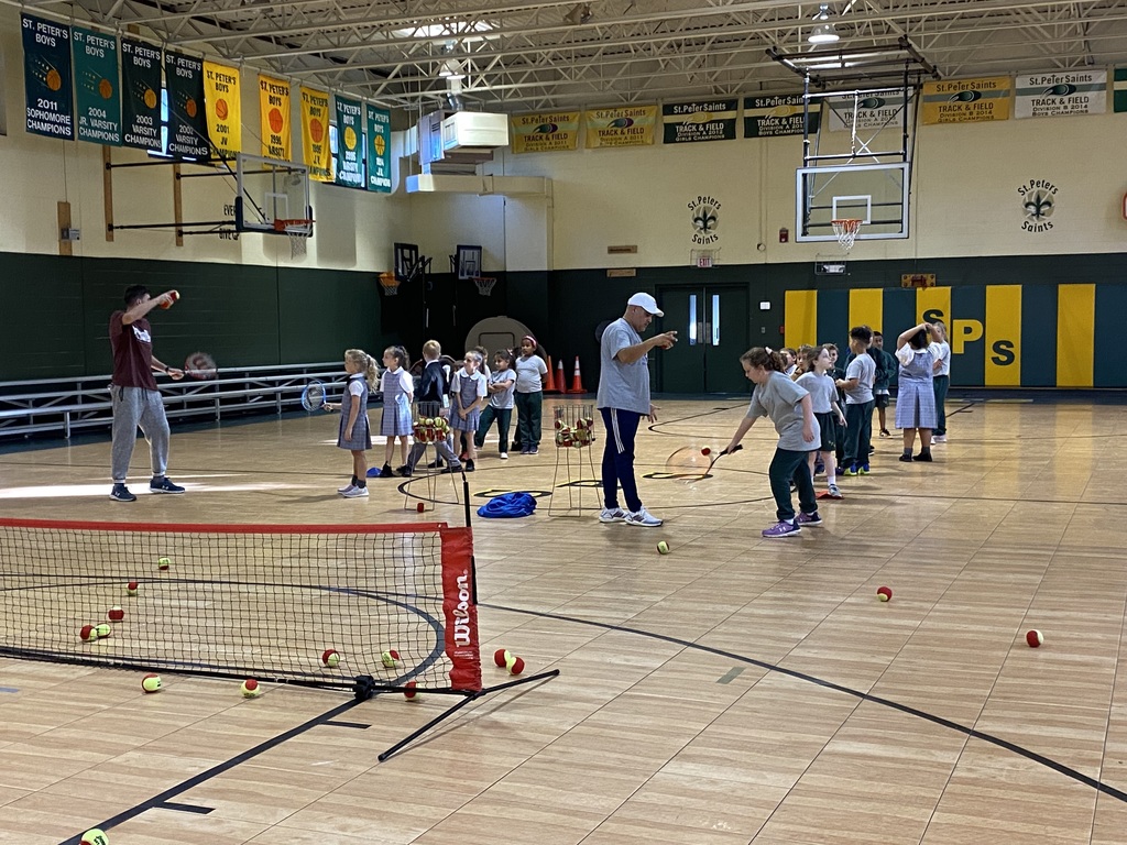 A group  of students practicing tennis swings.